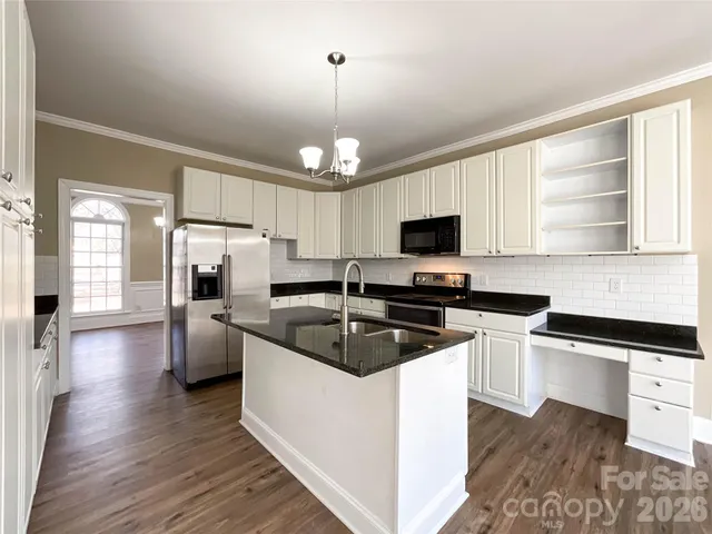 a kitchen with granite countertop a sink cabinets and stainless steel appliances