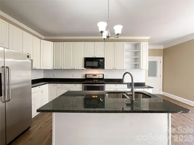 a kitchen with stainless steel appliances granite countertop a sink a refrigerator microwave and stove