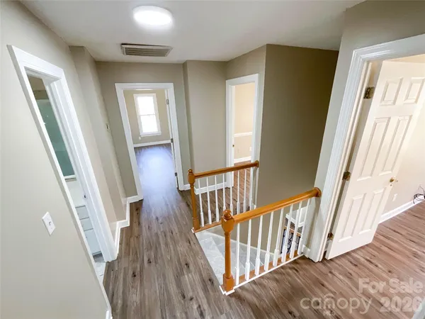 a view of staircase with wooden floor and fan