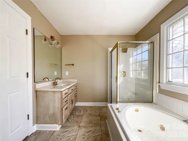 a bathroom with a tub sink and mirror