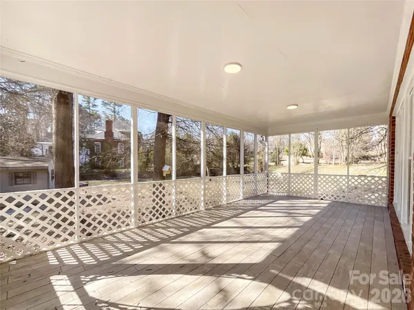 a view of a large room with wooden floor and floor to ceiling window