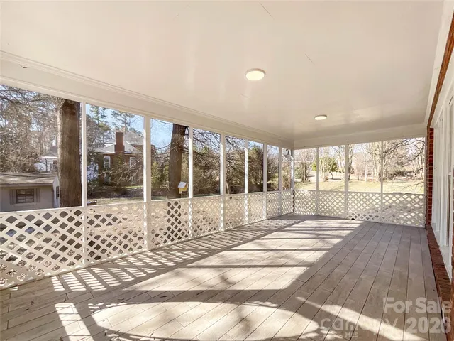 a view of a large room with wooden floor and floor to ceiling window