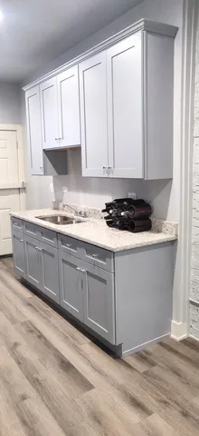 a kitchen with stainless steel appliances granite countertop a sink a stove and white cabinets