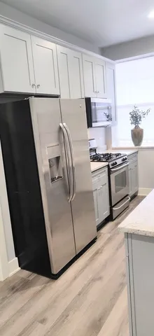 a kitchen with stainless steel appliances granite countertop a refrigerator a stove a sink and a microwave