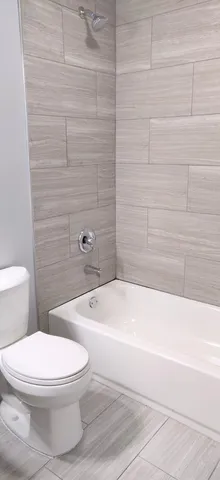 a white toilet and tub sitting next to a bathroom sink