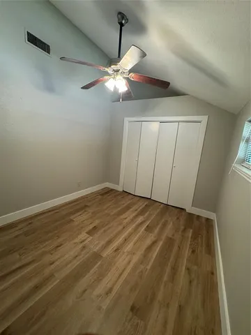 a view of an empty room with a chandelier fan