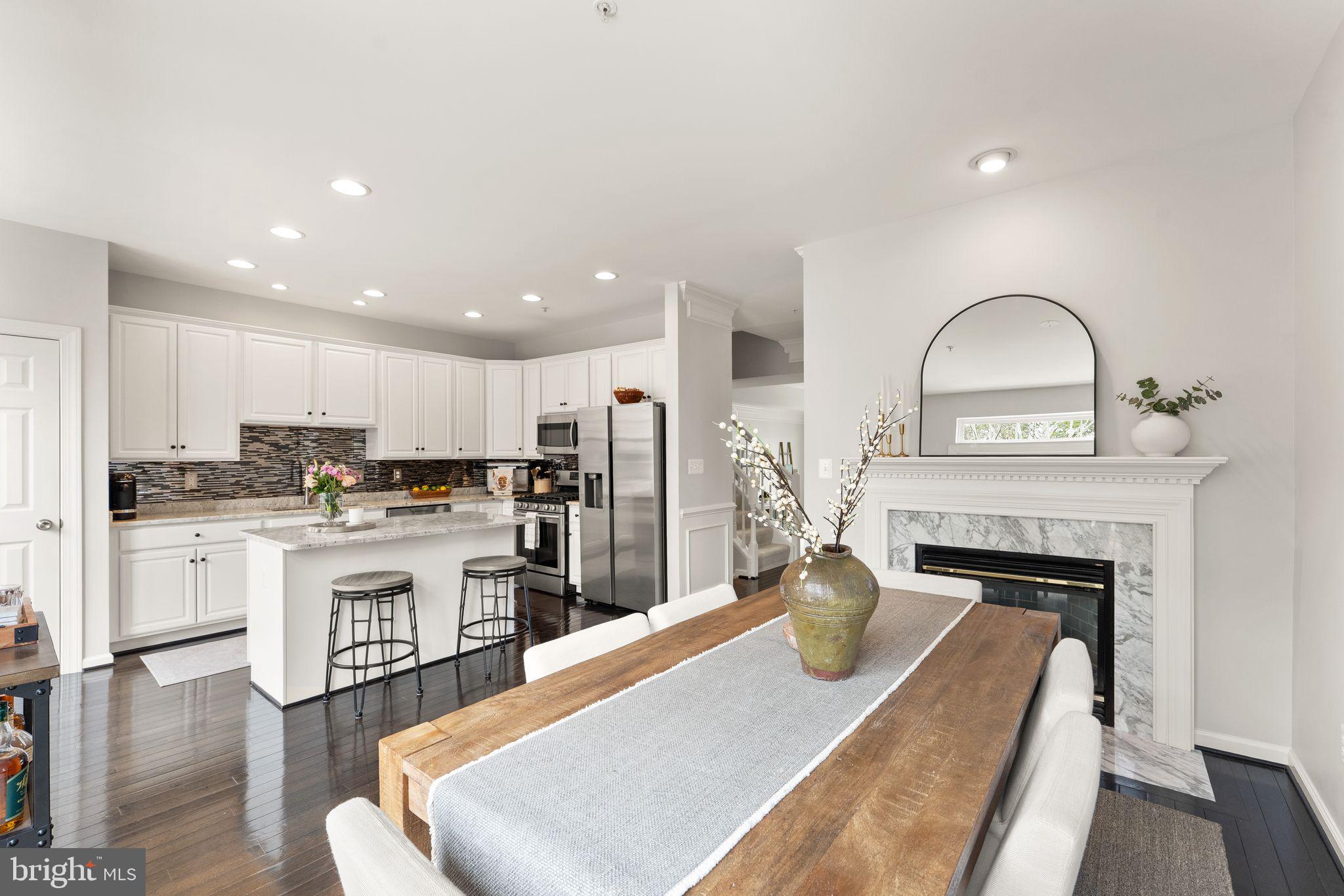 18168 Mill House Square Leesburg, VA 20176 - Photo 11 of 60 a living room with stainless steel appliances furniture a fireplace a flat screen tv and kitchen view