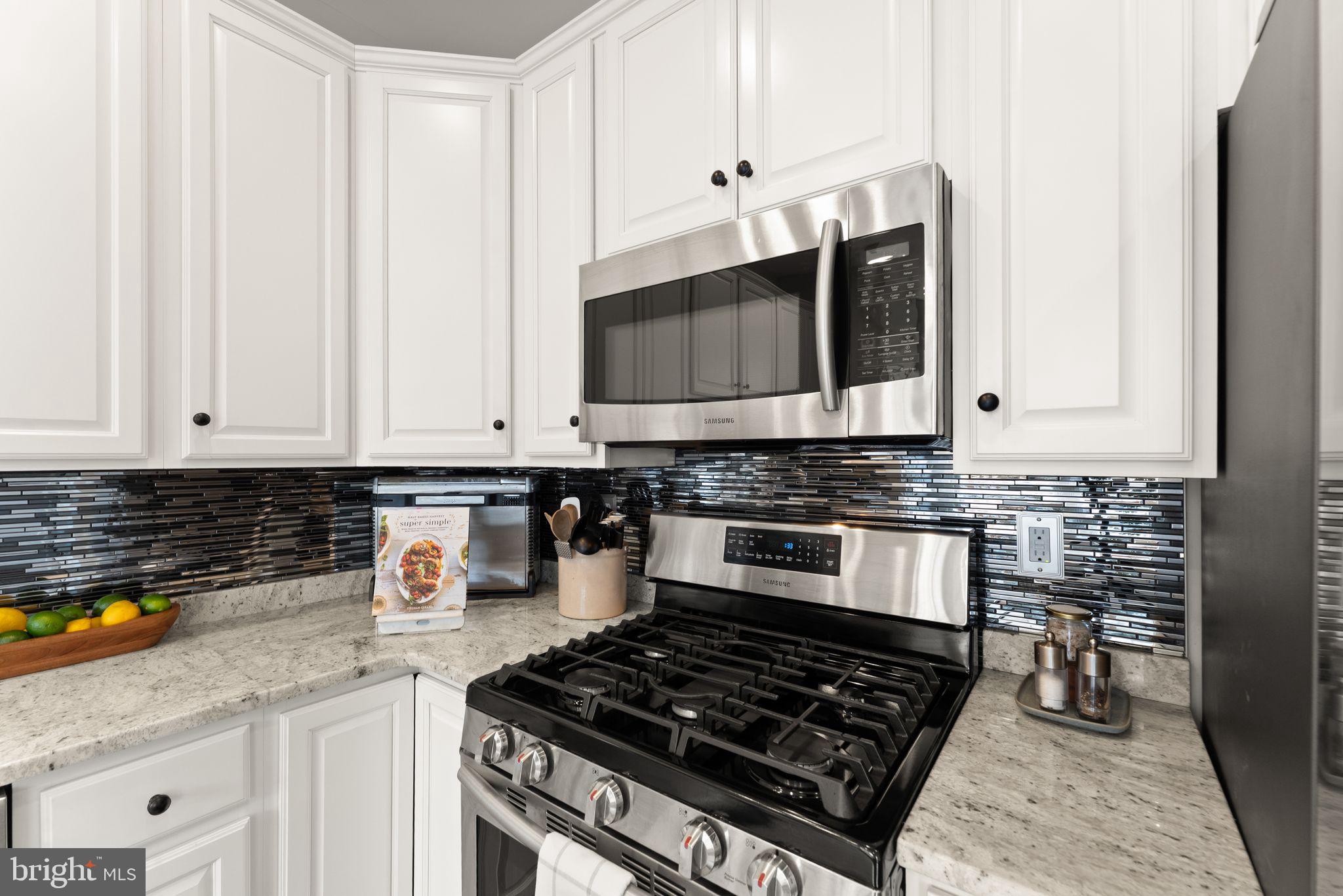 18168 Mill House Square Leesburg, VA 20176 - Photo 14 of 60 a kitchen with stainless steel appliances granite countertop a stove a sink and a microwave