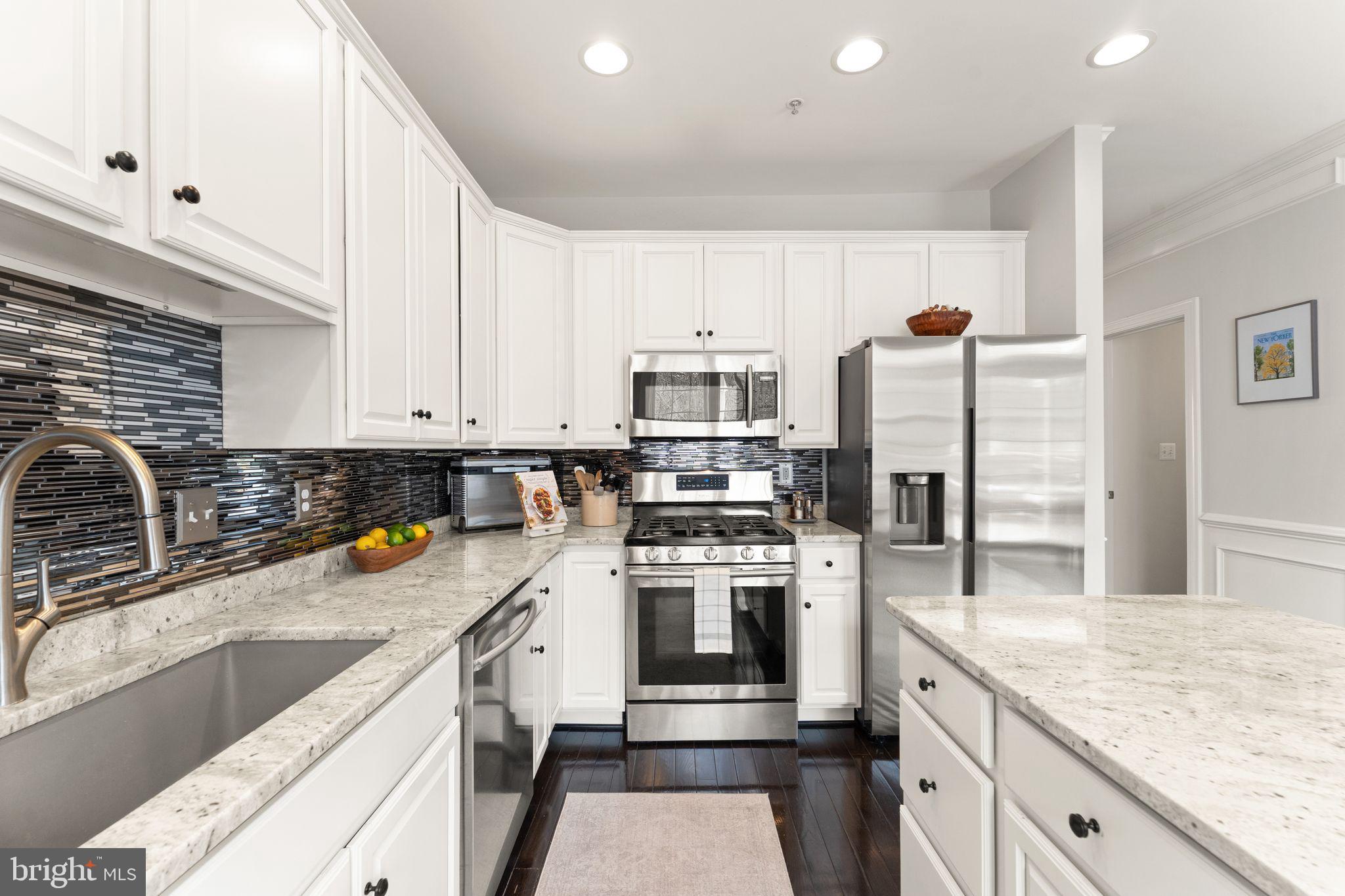 18168 Mill House Square Leesburg, VA 20176 - Photo 17 of 60 a kitchen with a sink a stove a refrigerator and cabinets