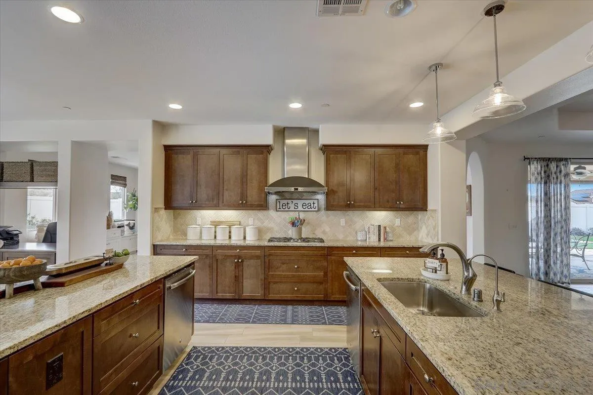 5620 Rancho Del Caballo Bonsall, CA 92003 - Photo 14 of 49 a large kitchen with granite countertop a sink and a refrigerator