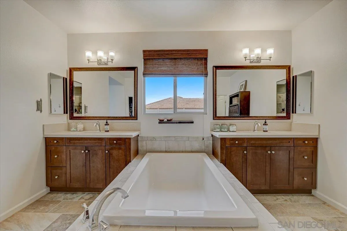 5620 Rancho Del Caballo Bonsall, CA 92003 - Photo 27 of 49 a spacious bathroom with a sink a large mirror and a bathtub and a double vanity