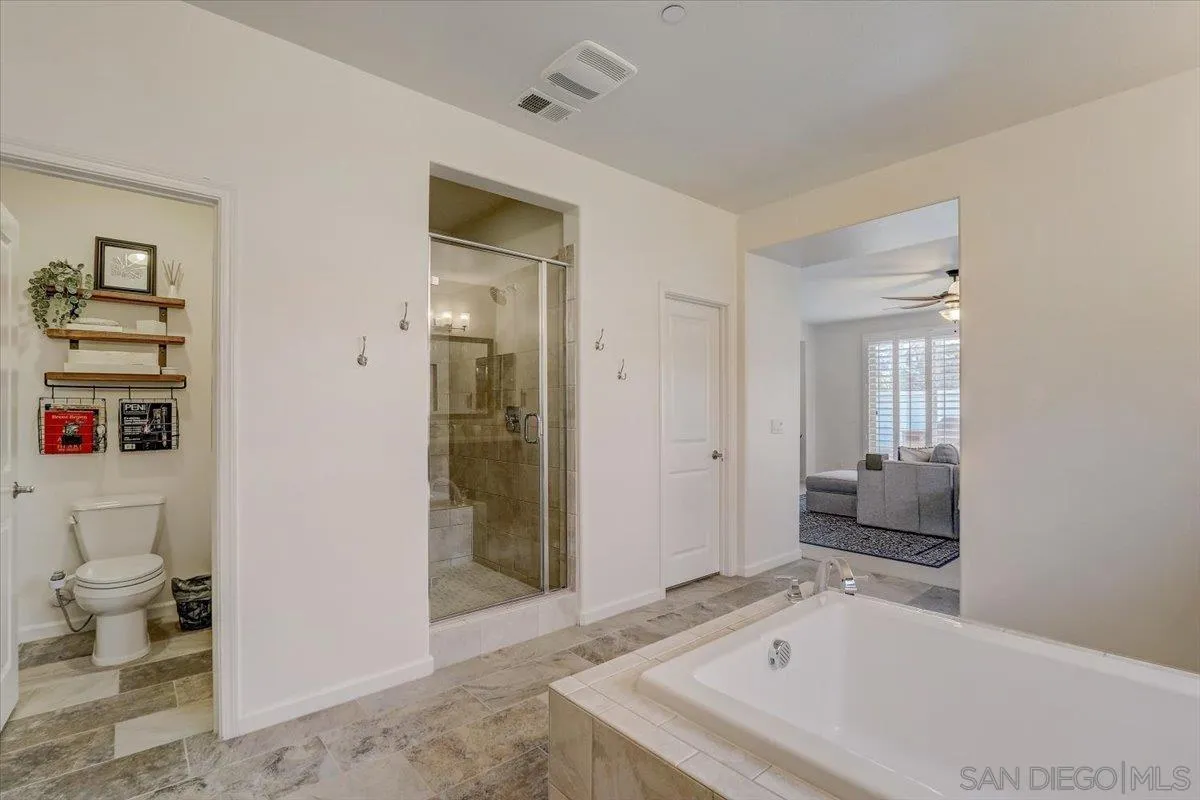 5620 Rancho Del Caballo Bonsall, CA 92003 - Photo 28 of 49 a bathroom with a tub a toilet and a shower