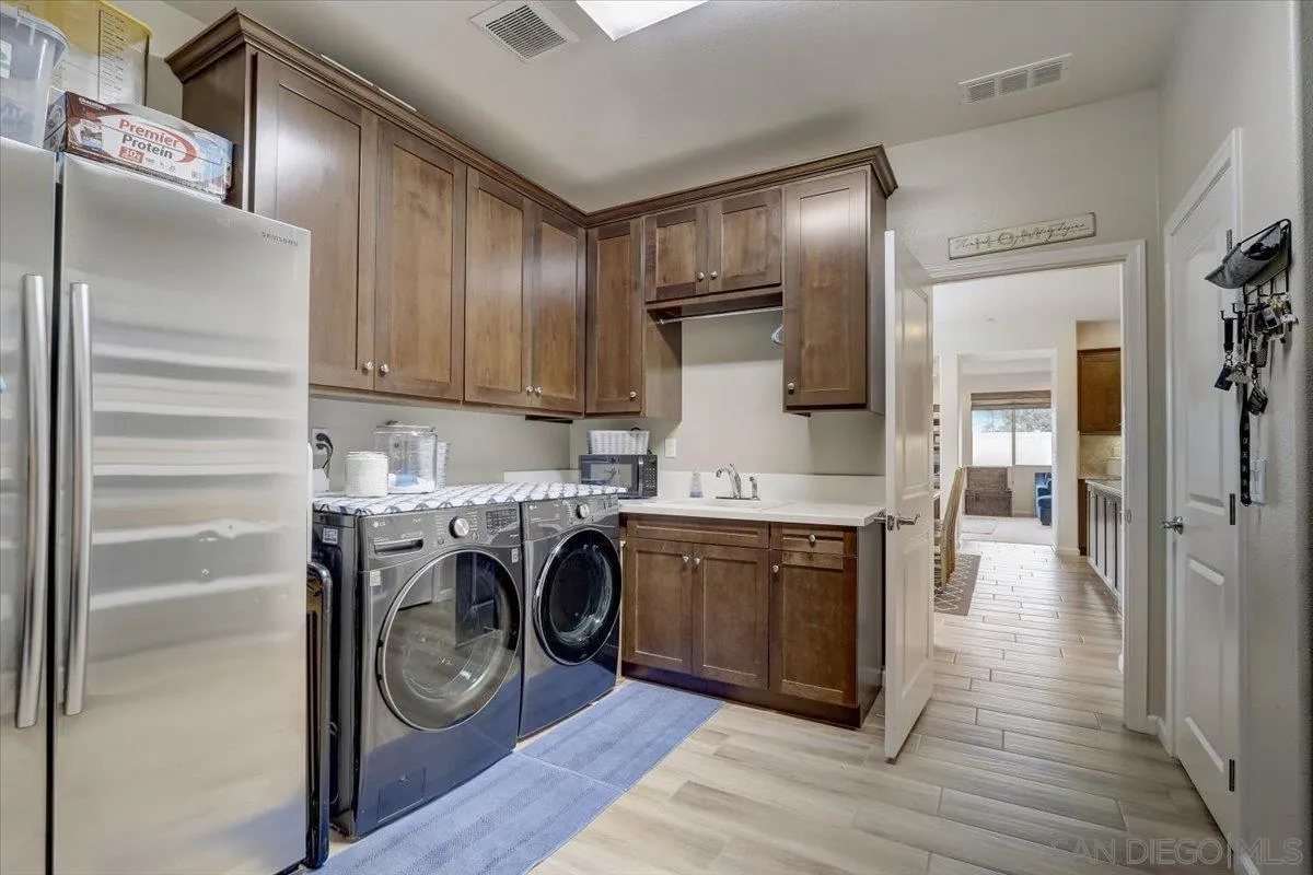 5620 Rancho Del Caballo Bonsall, CA 92003 - Photo 38 of 49 a kitchen with kitchen island wooden cabinets and stainless steel appliances