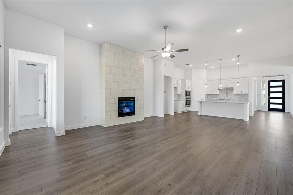 331 Trillium Street Oak Point, TX 75068 - Photo 12 of 36 a view of empty room with wooden floor and kitchen view