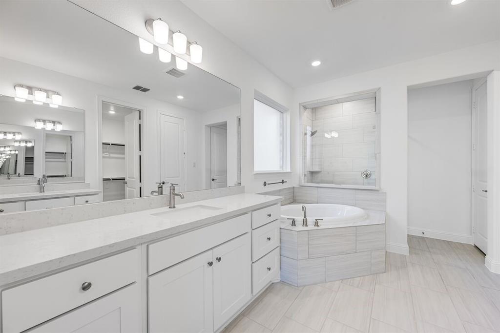 331 Trillium Street Oak Point, TX 75068 - Photo 18 of 36 a spacious bathroom with a double vanity sink a mirror and a bathtub