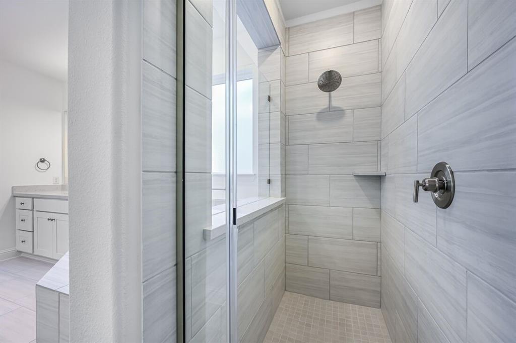 331 Trillium Street Oak Point, TX 75068 - Photo 20 of 36 a bathroom with a glass shower door