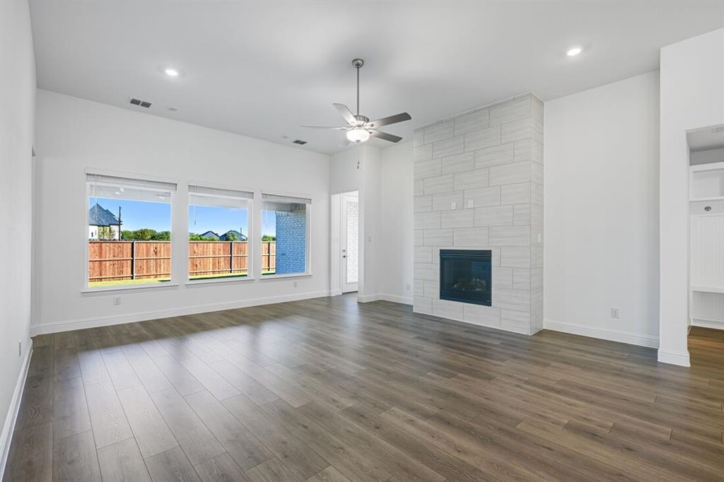 331 Trillium Street Oak Point, TX 75068 - Photo 4 of 36 an empty room with wooden floor fireplace and windows
