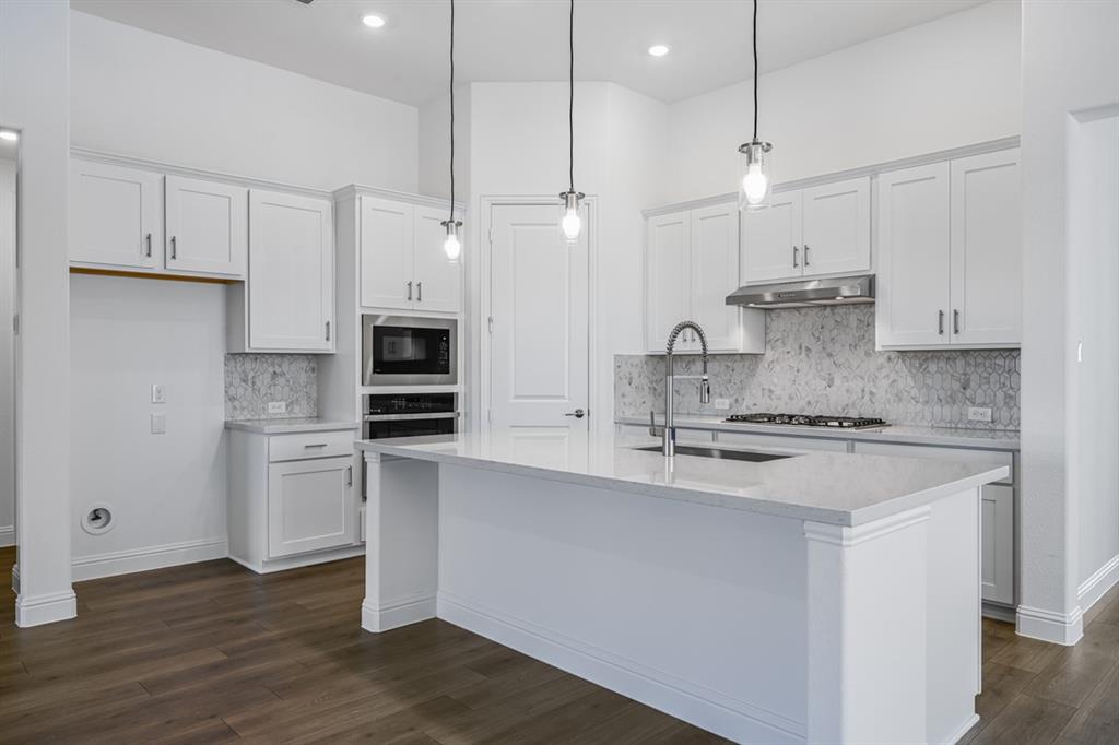 331 Trillium Street Oak Point, TX 75068 - Photo 9 of 36 a kitchen with stainless steel appliances granite countertop a sink a stove a refrigerator and island with wooden floor