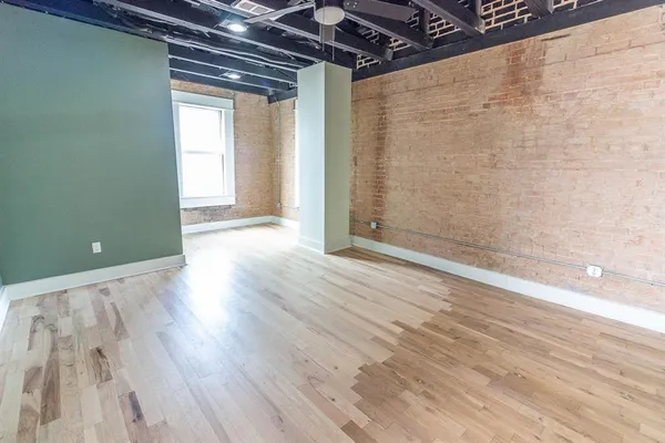 a view of a room with wooden floor and a window