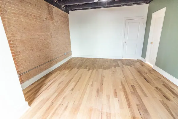 a view of a room with wooden floor
