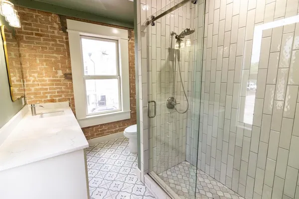 a bathroom with a granite countertop shower and a sink