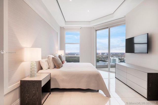 a bedroom with a large bed and a flat screen tv