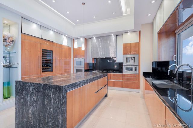 a large kitchen with stainless steel appliances granite countertop a sink and cabinets