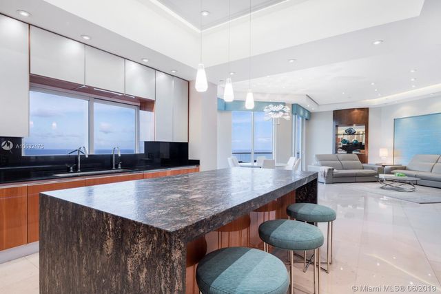 a large kitchen with lots of counter space and furniture