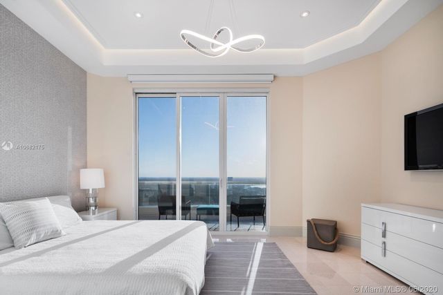 a bedroom with a bed and a flat tv screen