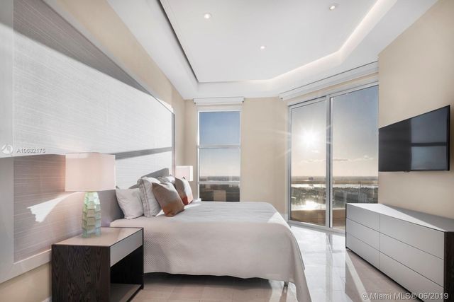 a bedroom with a large bed and a flat screen tv