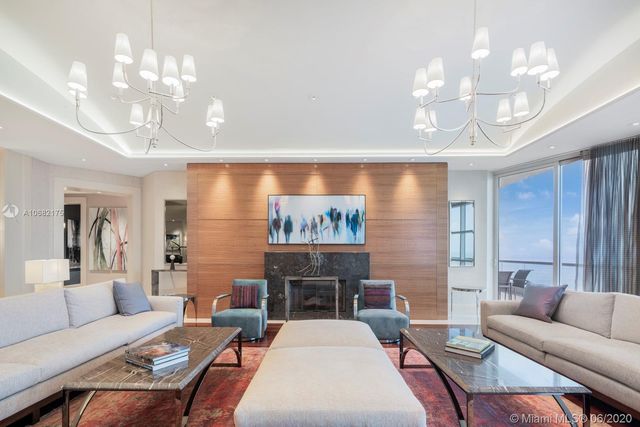 a living room with furniture a chandelier and a fireplace
