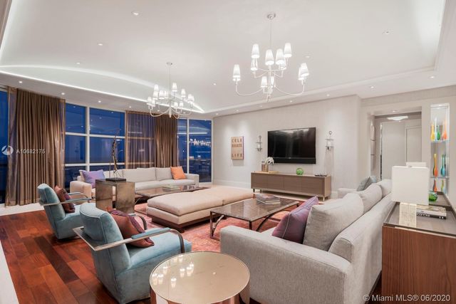 a living room with fireplace furniture and a chandelier