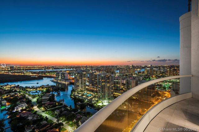 a view of a big yard of grass and palm trees