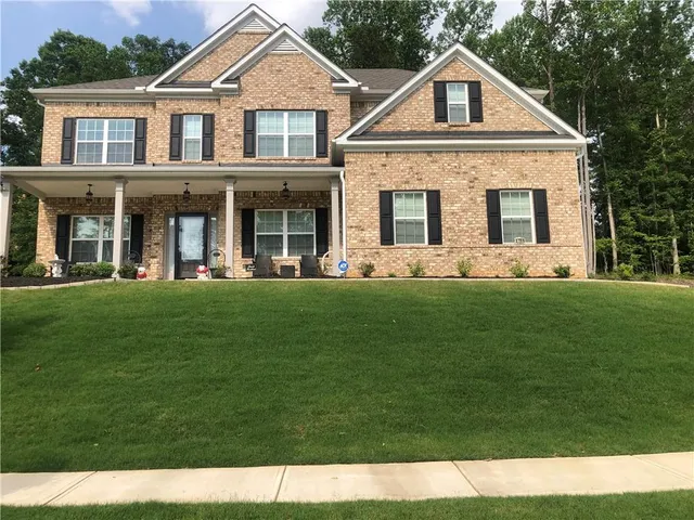 a front view of a house with a garden