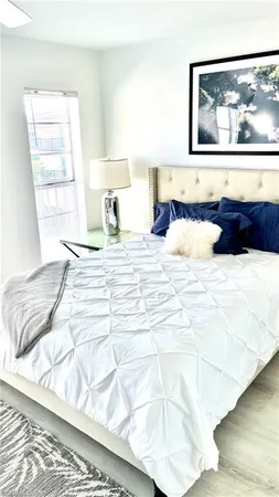 a bedroom with a bed and a large window
