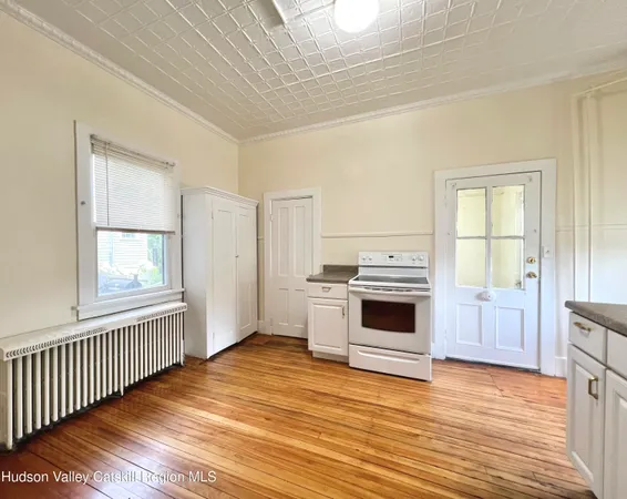 a view of a kitchen with wooden floor and electronic appliances
