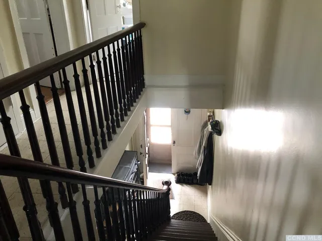 a view of staircase with railing and a window