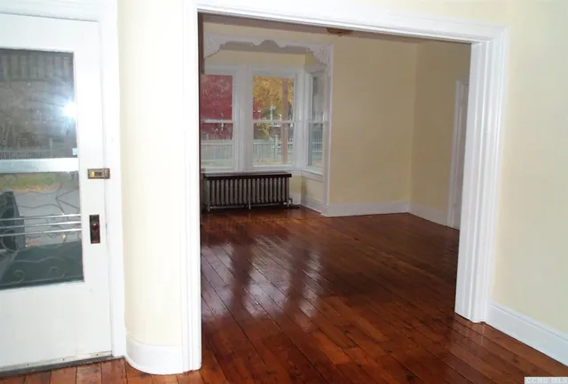 a view of a room with wooden floor and a window
