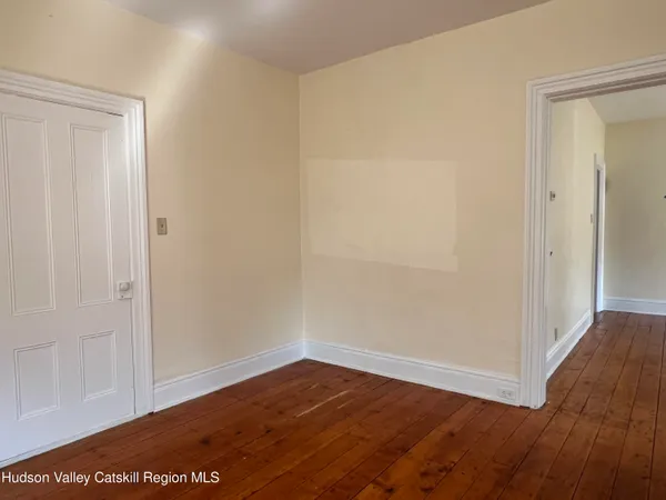a view of an empty room with wooden floor