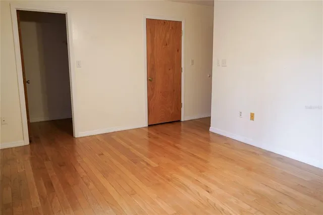 an empty room with wooden floor and closet