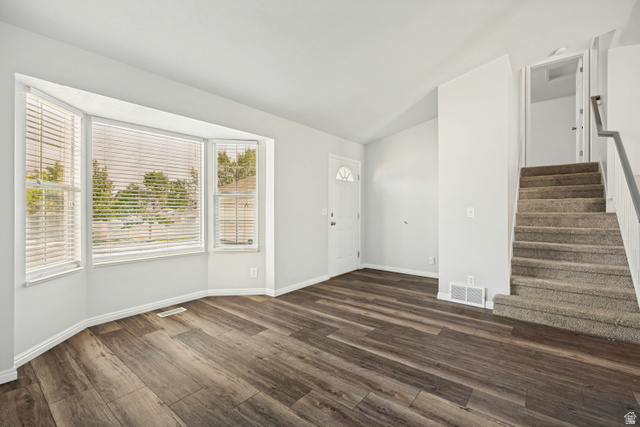 5529 Ridge Hollow Way Kearns, UT 84118 - Photo 4 of 23 Spacious room featuring wood-finish flooring, a multi-pane bay window, and light gray wall paint