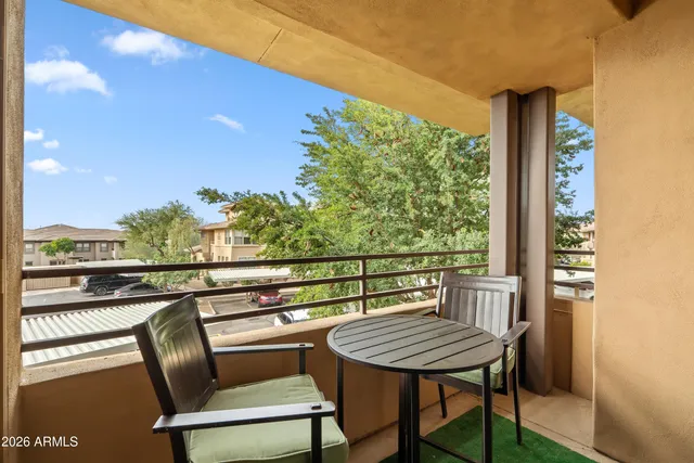 a patio with a table and chairs and potted plants