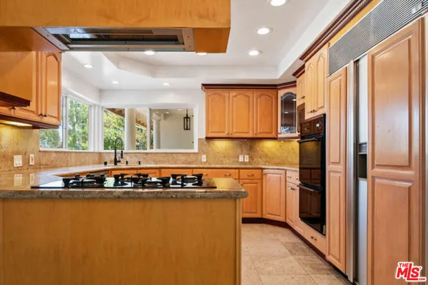 a kitchen with stainless steel appliances granite countertop a refrigerator and a stove top oven