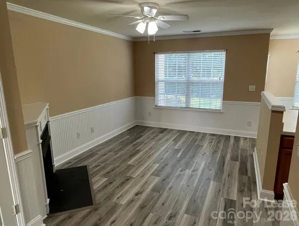 a view of a livingroom with wooden floor and a ceiling fan