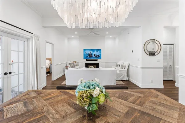 a view of a dining room and livingroom with furniture wooden floor a chandelier
