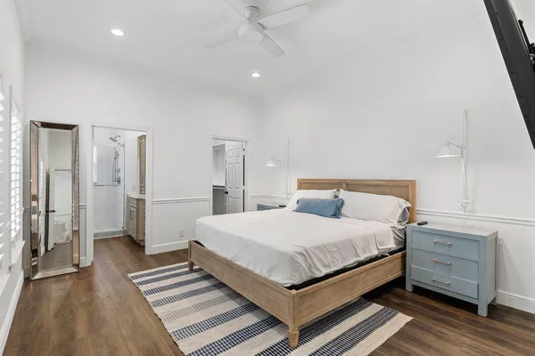 a bedroom with a large bed and wooden floor