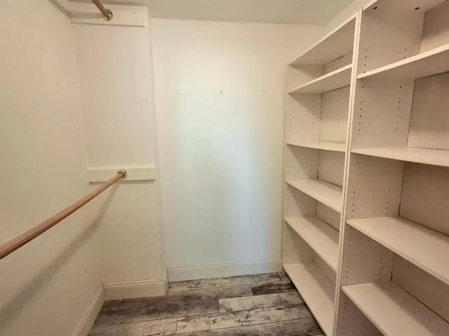 a view of walk in closet with empty racks