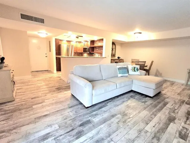 a living room with furniture and kitchen view