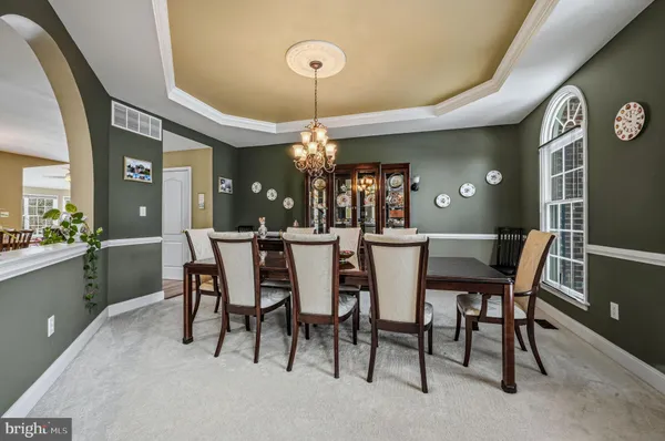 a dining room with furniture a chandelier and window