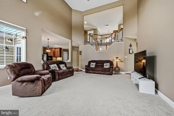 a view of a dining room and livingroom with furniture wooden floor a chandelier